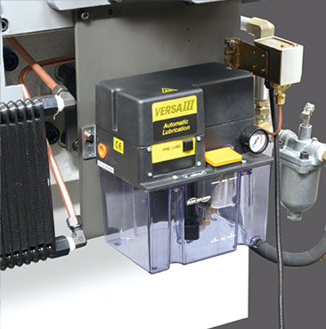 Side view of a heavy-duty foil stamping press showing safety guards and emergency stop button